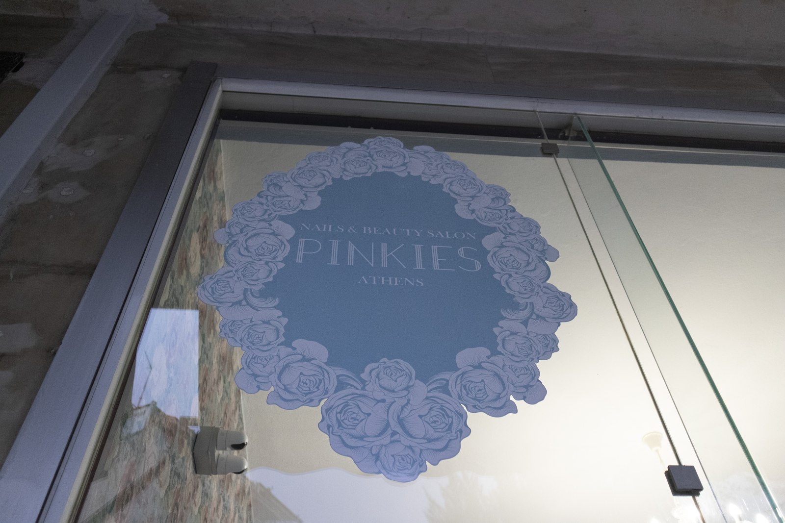 Το λογότυπο του Pinkies Nails and Beauty Salon στη βιτρίνα του καταστήματος